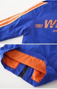 Detail of blue boys jacket with orange stripes, resin zipper and windproof inner lining