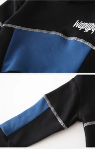Détail du sweat à capuche pour garçon avec coutures contrastées et broderie blanche