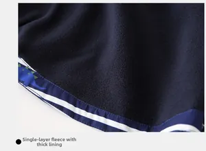 Detailed macro view of dark blue fleece lining with dinosaur and striped hem patterns