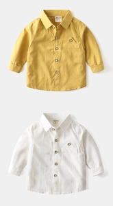 Detail of high-quality cotton boy's shirts in mustard yellow and white with chest pockets