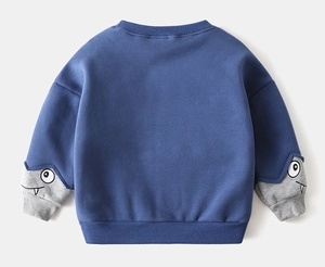 Detail view of navy blue boys sweatshirt featuring cartoon monster prints on grey sleeve cuffs