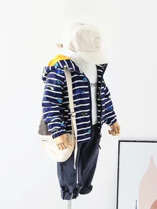 Detail of boys' navy dinosaur windbreaker jacket with striped hood and matching set