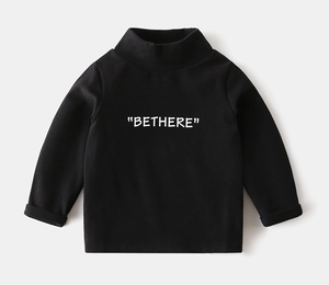 Detail of kids black turtleneck shirt featuring BETHERE lettering and soft thermal fabric