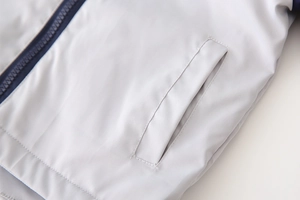 Detail view of the fleece jacket showing a side pocket and high-quality navy blue zipper