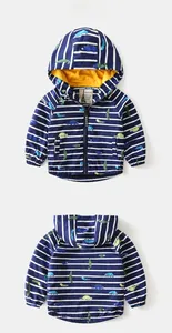 Detail of toddler hooded windbreaker featuring navy stripes and dinosaur prints with yellow lining