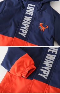 Detail der Kinderjacke mit Dino-Stickerei und marineblau-orangefarbenem Colorblocking