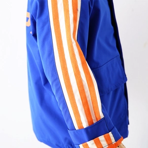Boy's electric blue sports jacket with orange-white striped sleeves and utility pocket