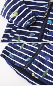 Detail of toddler hooded jacket featuring dinosaur prints and durable zipper closure