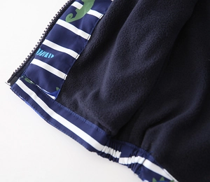 Detail of boys' thick hooded jacket showing navy fleece lining and dinosaur striped fabric