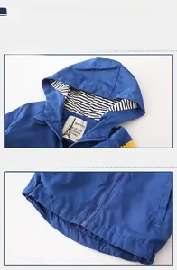 Detail view of boys blue hooded windbreaker with striped lining and quality zipper