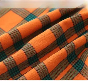 Macro du tissu à carreaux orange et bleu avec détails de tissage sergé doux