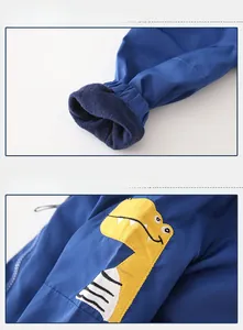 Detail of boys' blue hooded jacket showing thick fleece lining and dinosaur patch
