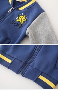Détail du blouson de baseball bleu avec broderie d'étoile jaune et fermeture éclair