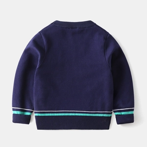 Close-up of ribbed cuffs and mint green stripes on navy blue knitted kids sweater