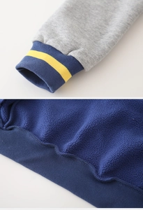 Détail de la veste de baseball pour garçon avec doublure polaire et poignets rayés