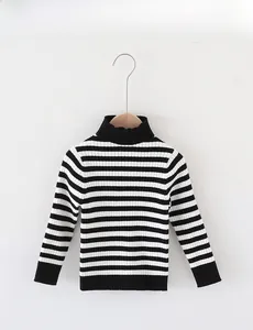 Detail of kids striped turtleneck sweater with black and white knit texture and ribbed cuffs
