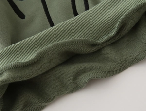 Nahaufnahme eines grünen Kinder-Sweatshirts mit warmem Fleece-Futter und Rippbündchen