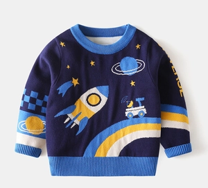 Detail of space-themed knitted sweater featuring rocket and planet patterns on navy blue fabric