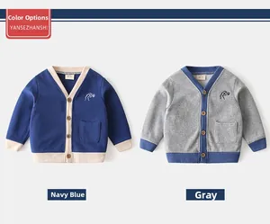 Detail view of navy and grey knit cardigans with dinosaur embroidery and wood buttons