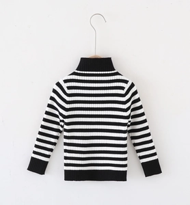 Detail of classic black and white striped turtleneck sweater with ribbed cuffs and hem