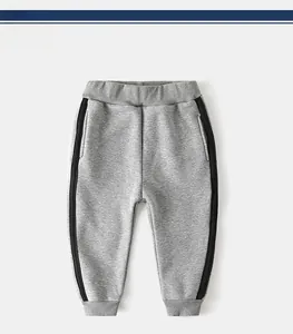 Detail view of children's grey sweatpants with elastic waist and black side stripes