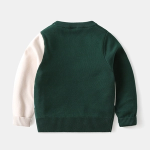 Detail view of children's ribbed cuffs and hem on two-tone knitted sweater