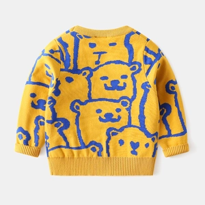 Close-up of ginger yellow kids sweater showing rib-knit collar and blue bear patterns