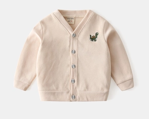Détail d'un cardigan tricoté pour bébé avec col en V et broderie petit dinosaure vert