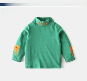 Detail of boys green high-neck t-shirt with orange collar embroidery and sleeve patch