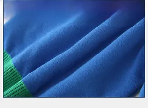 Close-up of royal blue jersey knit fabric and emerald green ribbed texture on kid sweater