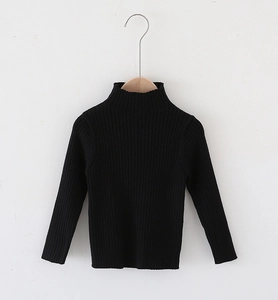 Close-up of black ribbed knit turtleneck sweater for children on a wooden hanger