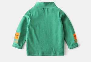 Detail of green turtleneck kids shirt showing embroidered sleeve patches and ribbed cuffs