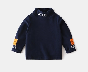 Detailed view of kids navy turtleneck sweatshirt with white collar embroidery and orange tag