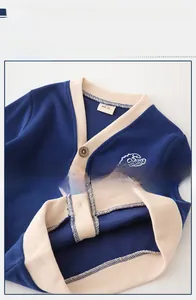 Detail of kids knit cardigan with dinosaur embroidery and textured button closure