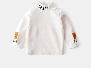 Detailed view of kids' mock neck top featuring orange patches and bold typography