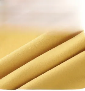 Gros plan sur la texture du tissu thermique jaune doux montrant les fibres fines et détails