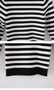 Detailed close-up of children's black and white striped ribbed knit sweater hem and cuffs