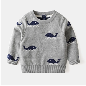 Detail of soft gray knit sweater for kids featuring cute blue whale jacquard pattern