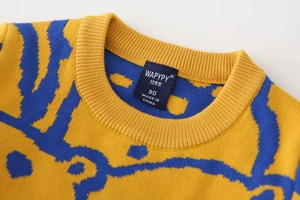 Close-up of ribbed crewneck detail on boys' jacquard knit sweater in yellow and blue
