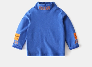 Close-up of boys blue turtleneck top with orange collar embroidery and patch details