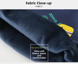 Détail macro de la doublure polaire douce et imprimé dinosaure sur sweat bleu chaud