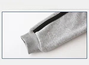 Detail of ribbed cuffs on gray fleece-lined jogger pants for kids with black side stripes