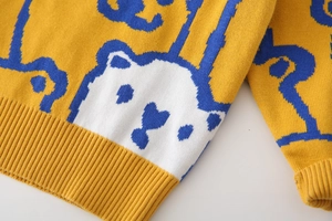 Detailed knit texture of ginger yellow boy sweater with cartoon bear jacquard pattern