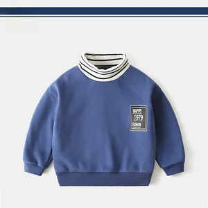 Detail of boys' thick turtleneck sweatshirt with striped collar and letter patch