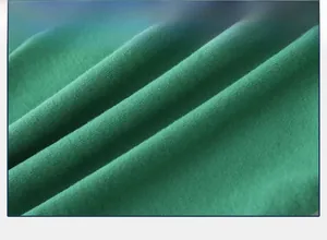 Detail of dark green knit fabric showing soft texture and horizontal weaving pattern