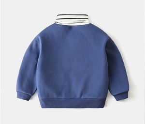 Detail view of boys thick blue sweatshirt featuring a striped turtle neck and ribbed cuffs