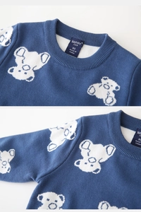 Macro detail of navy knit baby sweater featuring white koala jacquard and soft collar tag