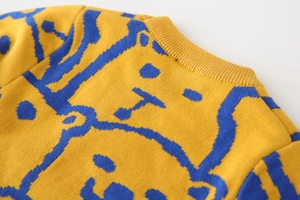 Detail of knitted ribbed neckline and cartoon bear pattern on thick children's sweater