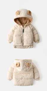 Detail of hooded kids quilted jacket with bear ears and warm fleece lining shown on white