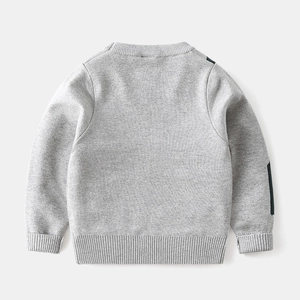 Detail view of children's grey knit sweater featuring ribbed cuffs and geometric pattern
